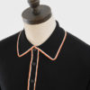 ART GALLERY CLOTHING MOD SIXTIES STYLE KNITWEAR ISLEY Black, long sleeved, three buttoned knitted polo shirt with ribbed front panel, orange & off white gold tipped collars, placket, cuffs & waistband